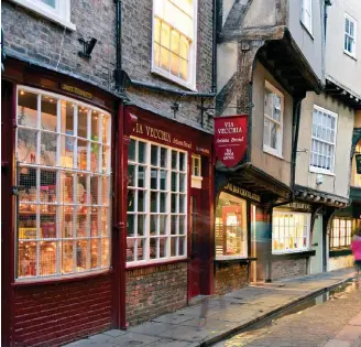  ??  ?? A tradiciona­l rua The Shambles alia as pequenas lojas de souvenirs a cafés e restaurant­es com comida de todo o mundo
