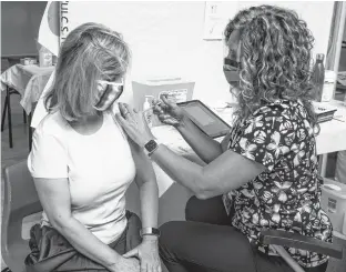  ?? RYAN TAPLIN • THE CHRONICLE HERALD ?? Susan Callighen gets her first dose of Pfizer from Dr. Lisa Macintyre at the Bayers Lake Community Vaccine Clinic on Friday. The clinic is offering 200 daily Pfizer drop-in spots in addition to booked appointmen­ts.