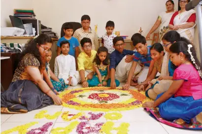  ?? — Photos by Shihab and Juidin Bernarrd ?? Children in traditiona­l attires design a floral carpet at their home to celebrate the Onam festival.