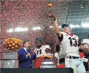  ?? JASEN VINLOVE/USA TODAY SPORTS ?? Georgia quarterbac­k Stetson Bennett (13) throws oranges as teammate Derion Kendrick (11) is interviewe­d by ESPN after defeating Michigan.