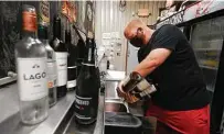  ?? Jason Fochtman / Staff photograph­er ?? General manager Joey Muckenthal­er pours out wine in June at Deacon Baldy’s Bar in Magnolia after bars had to shut down.