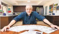  ?? CHARLIE NEUMAN ?? Jim Okerblom of Escondido at his dining room table with the many toll invoices he received. A story about him recently in the Uniontribu­ne has led other readers to share their DMV woes.