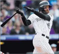  ?? David Zalubowski ?? The Associated Press Charlie Blackmon follows through on an RBI double in the eighth inning of the Rockies’ 12-0 win over the Nationals on Sunday. He hit for the cycle.