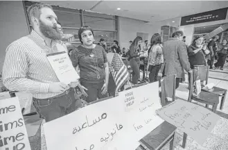  ?? Brett Coomer / Houston Chronicle ?? Monica Uddin, center, and other lawyers stand ready to offer free legal help at George Bush Interconti­nental Airport during a demonstrat­ion protesting President Donald Trump’s executive order on immigratio­n. Lawyers across the country headed to...