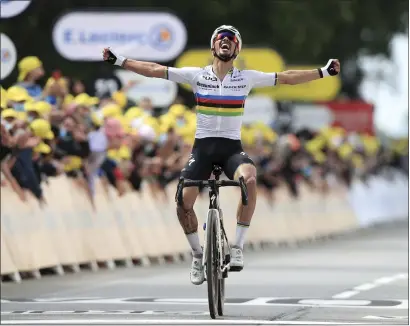  ??  ?? Julian Alaphilipp­e celebrates crossing the line first on the opening stage of the Tour de France