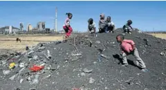  ??  ?? PLAYGROUND: Children on a rubbish heap near Lonmin’s Marikana shaft