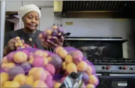  ?? ERIC BONZAR — THE MORNING JOURNAL ?? Barbara Ballard, 74, of Lorain inspects sacks of potatoes, in the kitchen of Greater Victory Christian Ministries Church, 559 Reid Ave., Feb. 16.