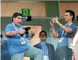  ?? GETTY IMAGES ?? Argentine superstar Lionel Messi, left, cuts a dejected figure during the match, while Diego Maradona didn’t look too thrilled with what he saw from the stands as a bystander takes his photo.
