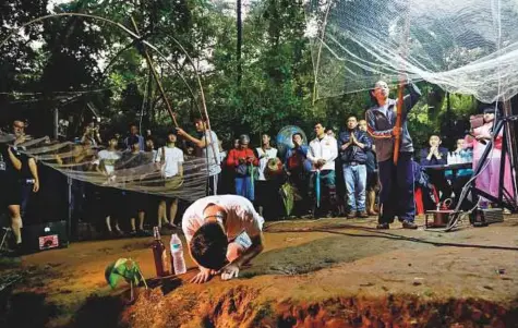  ?? AFP ?? Relatives perform a ritual yesterday morning at the entrance of Tham Luang cave, while rescue workers conduct operations to find the missing members of the children’s football team at the cave in Khun Nam Nang Non Forest Park, Thailand.