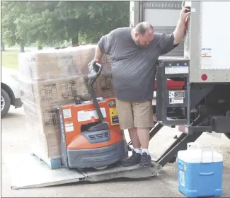  ?? Katie West • Times-Herald ?? Cody LaRue, with the Food Bank of Northeast Arkansas, unloads boxes of commoditie­s at the Forrest City Sports Complex this morning. Residents were able to pick up boxes in the drivethrou­gh event with proper documentat­ion and identifica­tion.