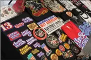  ?? ?? Patches, stickers and t-shirts representi­ng Americana adorn a display table belonging to Oliver Peck’s Elm Street Tattoos in Oroville on Sunday.