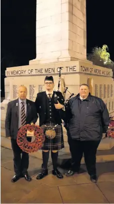  ??  ?? Lament A piper played at Airdrie war memorial at 6am on the 100th anniversar­y of the Armistice; pictured with armed forces champion David Cullen, left, and council colleague Trevor Douglas