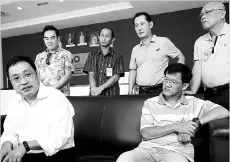  ??  ?? Chong (seated at left) speaks to reporters before submitting the formal report.Also seen are Liew (seated) and the other four shophouse owners.