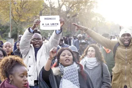  ??  ?? A protester holds a placard reading ‘No to slavery in Libya’ during a rally in Paris on Saturday. (AFP)