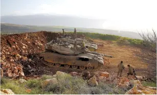  ??  ?? SOLDIERS STAND atop tanks near the Lebanon border in 2015.