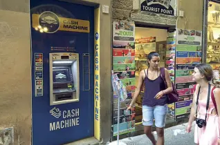  ??  ?? Senza banca Due dei tanti sportelli spuntati in centro in negozi per lo più rivolti ai turisti