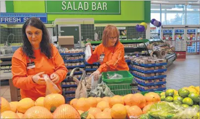  ?? CHRIS SHANNON/CAPE BRETON POST ?? Sydney River Atlantic Superstore personal shoppers Jeanette Morrison, left, and Margaret Pickup, select a variety of fruit to fill online orders through the new click-and-collect service, Wednesday. Atlantic Superstore, owned by Loblaws Companies Inc.,...