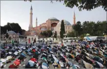  ??  ?? Muslims perform evening prayers in front of the Hagia Sophia, after a court decision that paves the way for it to be converted from a museum back into a mosque in Istanbul yesterday.