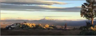  ?? AP PHOTO / GILLIAN FLACCUS ?? Joe Krenowicz, executive director of the Madras-Jefferson County Chamber of Commerce, looks toward Mt. Jefferson as the sun rises over Madras, Oregon on June 13.