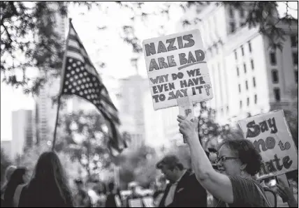  ?? CP Photo ?? People protest against the white supremacis­t movement and racism outside the United States consulate in Toronto on Monday.