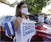  ?? SAM NAVARRO Special to the Miami Herald ?? Maria Belen Valladares holds a Nicaraguan­s for Biden sign before the start of a caravan in support of the Democratic presidenti­al candidate on Sept. 26 at Ruben Dario Park.