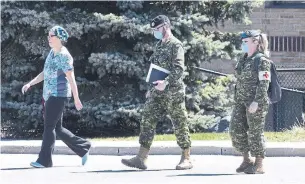  ?? CHRIS YOUNG THE CANADIAN PRESS FILE PHOTO ?? A staff member escorts members of the Canadian military into a Pickering long-term-care home in April. Nearly 2,000 Ontarians have died in COVID-19 outbreaks at long-term-care homes.