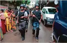  ?? AP ?? Policemen return after raiding a five-storey building in Dhaka yesterday.