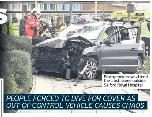  ??  ?? Emergency crews attend the crash scene outside Salford Royal Hospital