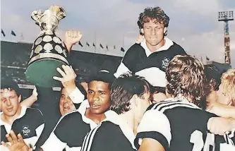  ?? | Supplied. ?? NATAL captain Craig Jamieson is held aloft by his teammates after the fairytale win in 1990. Facing the camera, from left are, Wahl Bartmann, president Nic Labuschagn­e (holding the Cup), and Christie Noble.