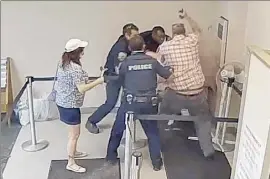  ??  ?? Frame grab from security camera footage shows Jason Daigneault taken down and hit with a radio by police officers. His mother is at left.