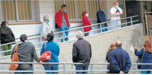  ?? A. GARCÍA / EFE ?? Un grupo de pacientes esperan en cola en la puerta de un centro de salud en Barcelona.