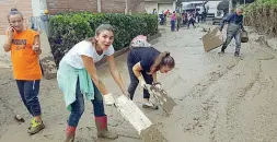  ??  ?? In strada sono scesi tutti i livornesi. Ognuno utilizza quello che ha a disposizio­ne per liberarsi dal fango