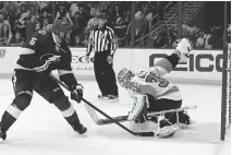  ?? MIKE CARLSON/GETTY IMAGES ?? Jason Garrison of the Lightning scores the first 3-on-3 overtime goal of the regular season on Steve Mason Thursday.