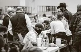  ?? Jon Shapley / Staff photograph­er ?? Election workers prepare before the release of Harris County’s early voting returns Nov. 3 at NRG Arena.