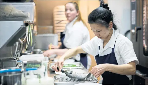  ?? COLE BURSTON PHOTOS FOR THE TORONTO STAR ?? Chef-owner Anna Chen plates her steamed sea bream dish.