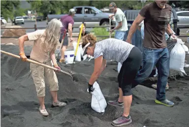  ?? THOMAS HAWTHORNE/THE REPUBLIC ?? Community members and volunteers fill sand bags to prepare for predicted flooding in Flagstaff Wednesday. Residents in the Sunnyside community planned for flooding feared to be worsened due to the fire.