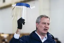  ?? GETTY IMAGES ?? MOBILIZING INDUSTRY: New York Mayor Bill de Blasio holds a face shield Thursday as he speaks to the media at the Brooklyn Navy Yard in New York City where firms have begun manufactur­ing personal protective equipment.