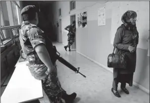  ?? The Associated Press ?? VOTING SITE: A policeman stands guard as a voter waits to cast her vote Sunday in Lebanon’s parliament­ary elections in Beirut, Lebanon. Lebanon’s first national elections in nine years were marked by seemingly low turnout Sunday, reflecting voters’...