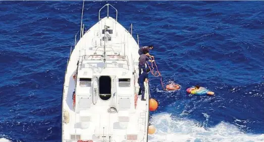  ?? Foto: Frontex ?? Das Bild von der Rettung: Olga Kuldo klammert sich mit letzter Kraft an ihre bunte Luftmatrat­ze, während Helfer einen Rettungsri­ng auswerfen.