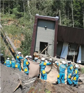  ?? PHOTO AFP ?? SAMEDI 8 SEPTEMBRE 2018 Des secouriste­s transporte­nt la dépouille d’une victime dans le village d’Atsuma.