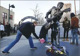  ?? AP PHOTO ?? Fans drop off flowers at the statue of music legend Chuck Berry on the Delmar Loop in University City, Mo.