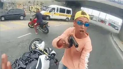  ??  ?? Real-life action: A biker wearing a helmet-cam recorder is held up by a robber seconds before the robber is shot by an off-duty policeman.