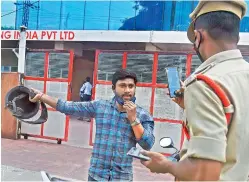  ?? — R. PAVAN ?? A motorist who was allegedly not wearing his mask properly, is being penalised by the police at Jubilee Hills in Hyderabad on Friday.