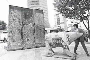  ?? LEE JIN-MAN/AP ?? A woman walks near pieces of the Berlin Wall given by Germany to Seoul as a “symbol of hope” for Korean unificatio­n.