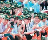  ?? LI GANG / XINHUA ?? Spectators gather outside the Shek Kong barracks on Friday to watch President Xi Jinping inspect the People’s Liberation Army garrison in the Hong Kong Special Administra­tive Region.