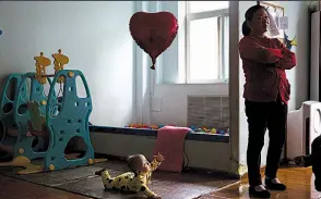  ?? AP/NG HAN GUAN ?? A child reaches toward an aide at a foster home outside Beijing that’s operated by the New Hope Foundation, which provides care for babies with deformitie­s that can be corrected by surgery. Chinese families sometimes abandon children with medical...