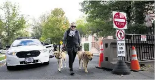  ?? AP ?? Eine Nachbarin von Obama (nicht Hillary Clinton!) läuft an einem Polizei-Checkpoint vorbei.