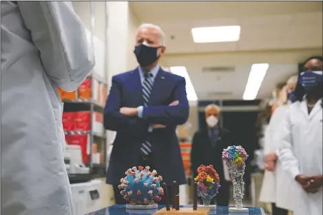  ??  ?? President Joe Biden visits the Viral Pathogenes­is Laboratory at the National Institutes of Health in Bethesda, Md. At bottom center is a model of the covid-19 virus. On Friday, The Associated Press reported on stories circulatin­g online incorrectl­y asserting Biden restored taxpayer funding for the Wuhan Institute of Virology. Social media users are falsely claiming the Biden administra­tion is bankrollin­g the Wuhan Institute of Virology, a Chinese lab that has faced unproven allegation­s that the coronaviru­s leaked from the facility leading to the global covid-19 pandemic.
(AP/Evan Vucci)