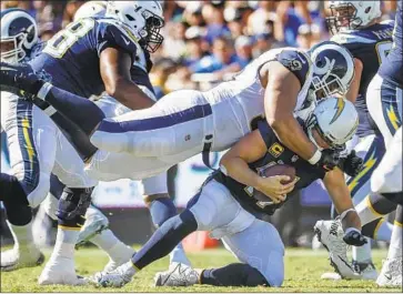  ?? Robert Gauthier Los Angeles Times ?? CHARGERS QUARTERBAC­K Philip Rivers is sacked by Rams defensive lineman Ndamukong Suh during a third-quarter drive at the Coliseum. Suh’s first sack as a Ram was met with the crowd’s “Suuuuh’’ approval.