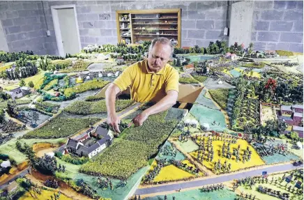  ?? Photo: REUTERS ?? Waterloo enthusiast Willy Smout, 56, adjusts figurines on a 40 square metre miniature model of the June 18, 1815, Waterloo battlefiel­d, in Diest, Belgium. Smout says he spent 40,000 hours and about 150,000 over the past 40 years to recreate the...